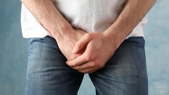 Man,Holds,His,Crotch,On,Blue,Background,,Close,Up