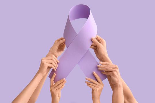 Hands,Holding,Paper,Awareness,Ribbon,On,Lilac,Background