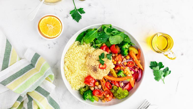 Baked vegetables with hummus bowl. Salad with baked potato, zucchini, broccoli and hummus.